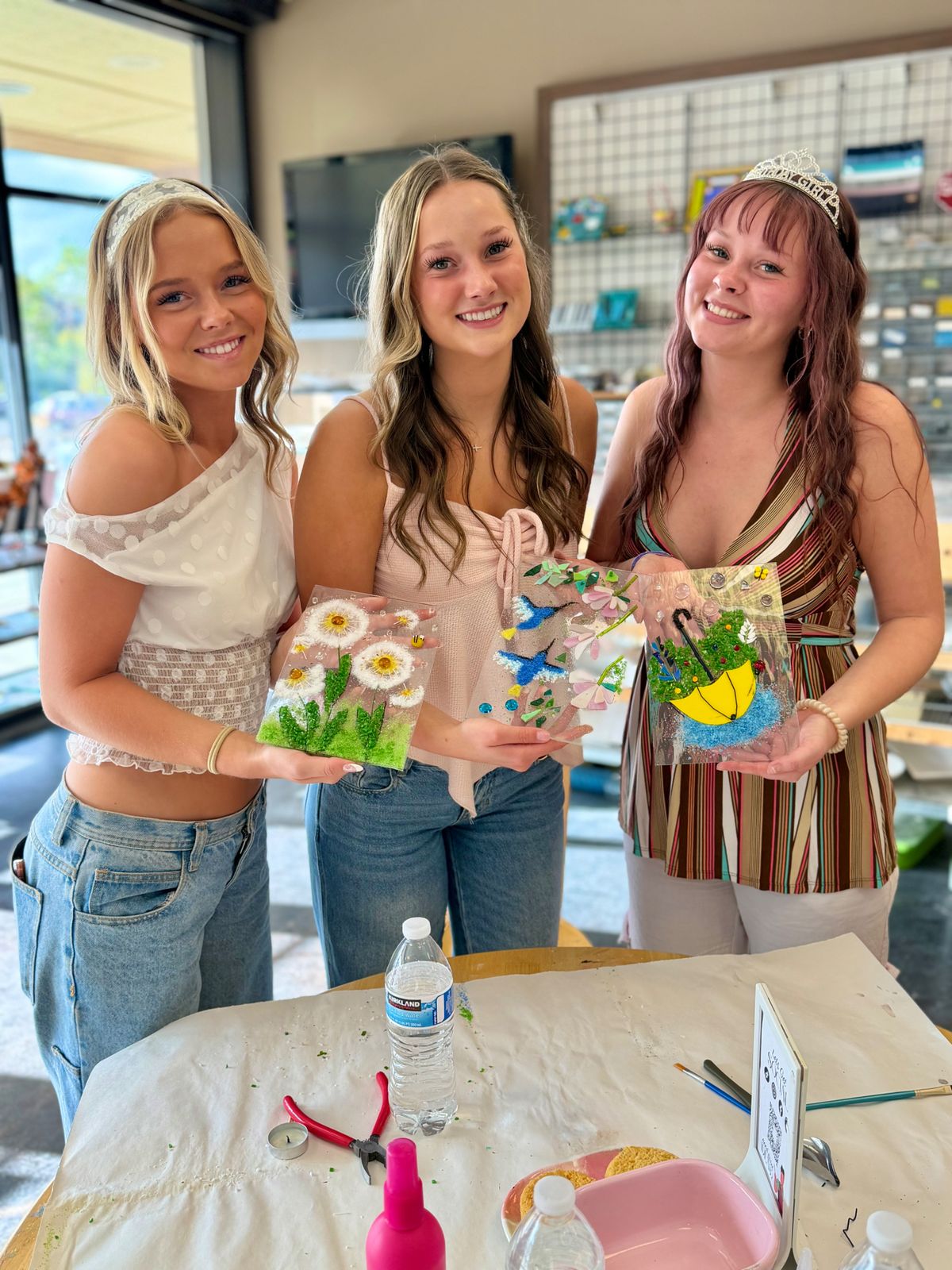 Three guests holding their finished glass fusing projects at Paint Fusion in Park City
