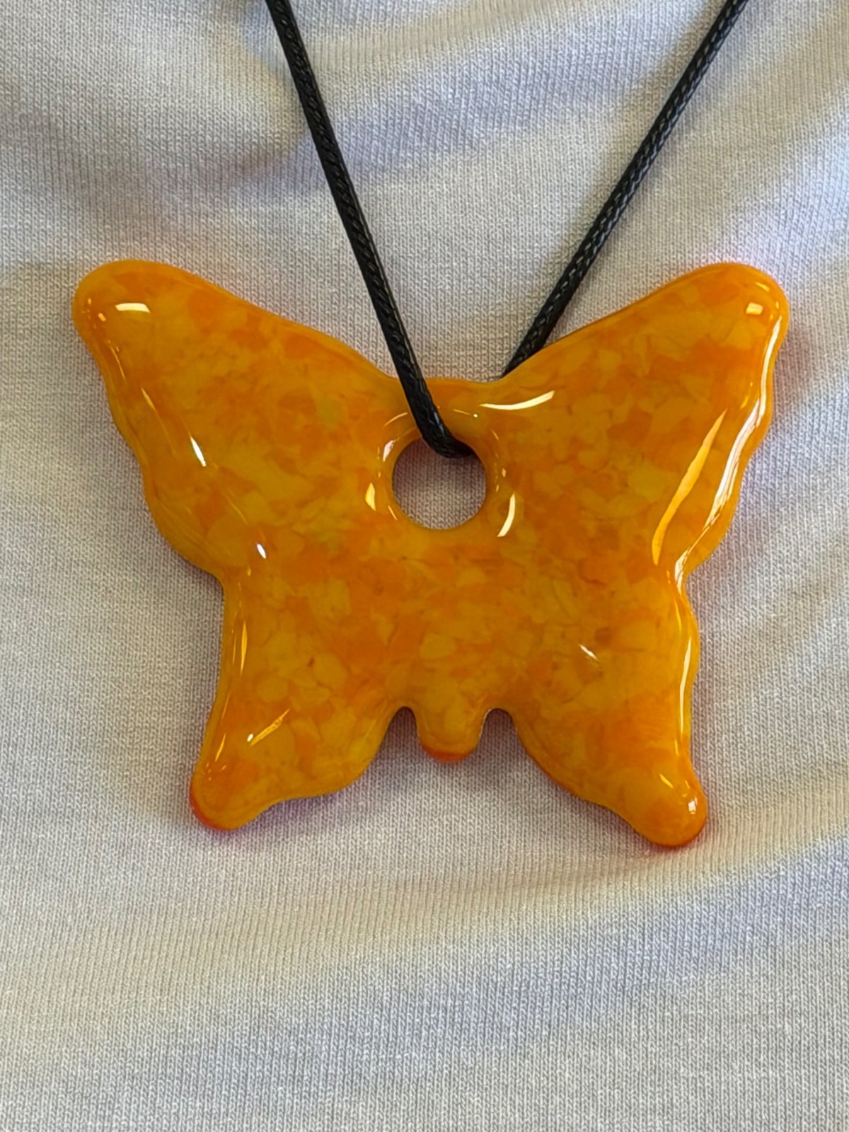 Glossy orange fused glass butterfly pendant