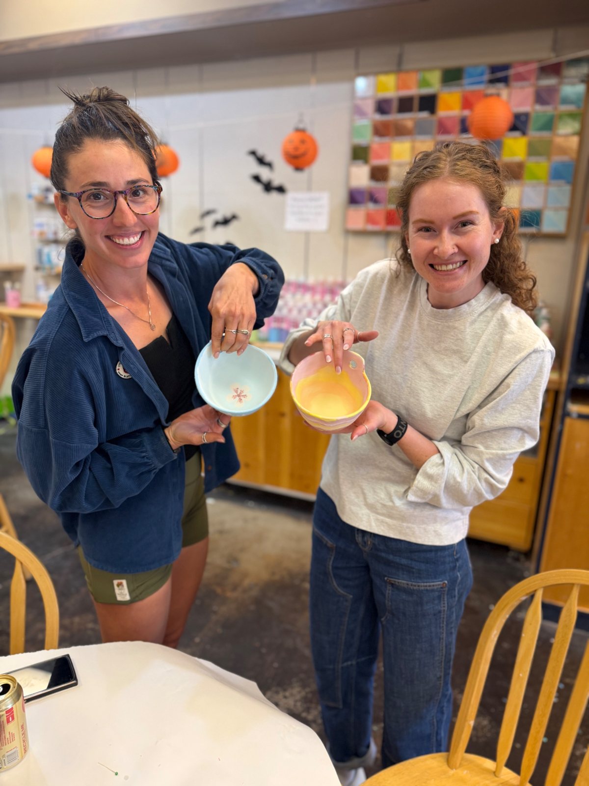 Their hand-painted bowls up close — a cherry-blossom branch and a sunrise swirl. — a Creative Super-Star at Paint Fusion Park City