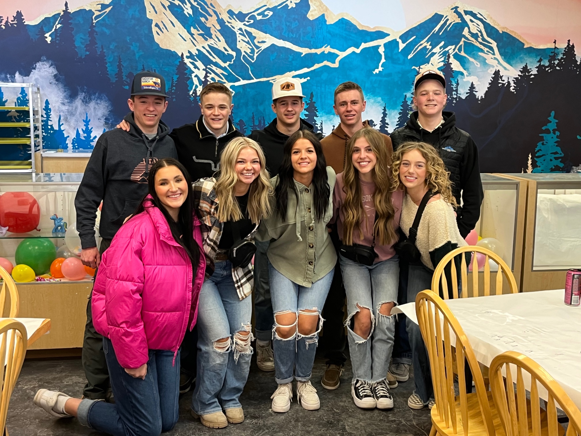 A group of friends in front of the mountain mural at Paint Fusion Park City