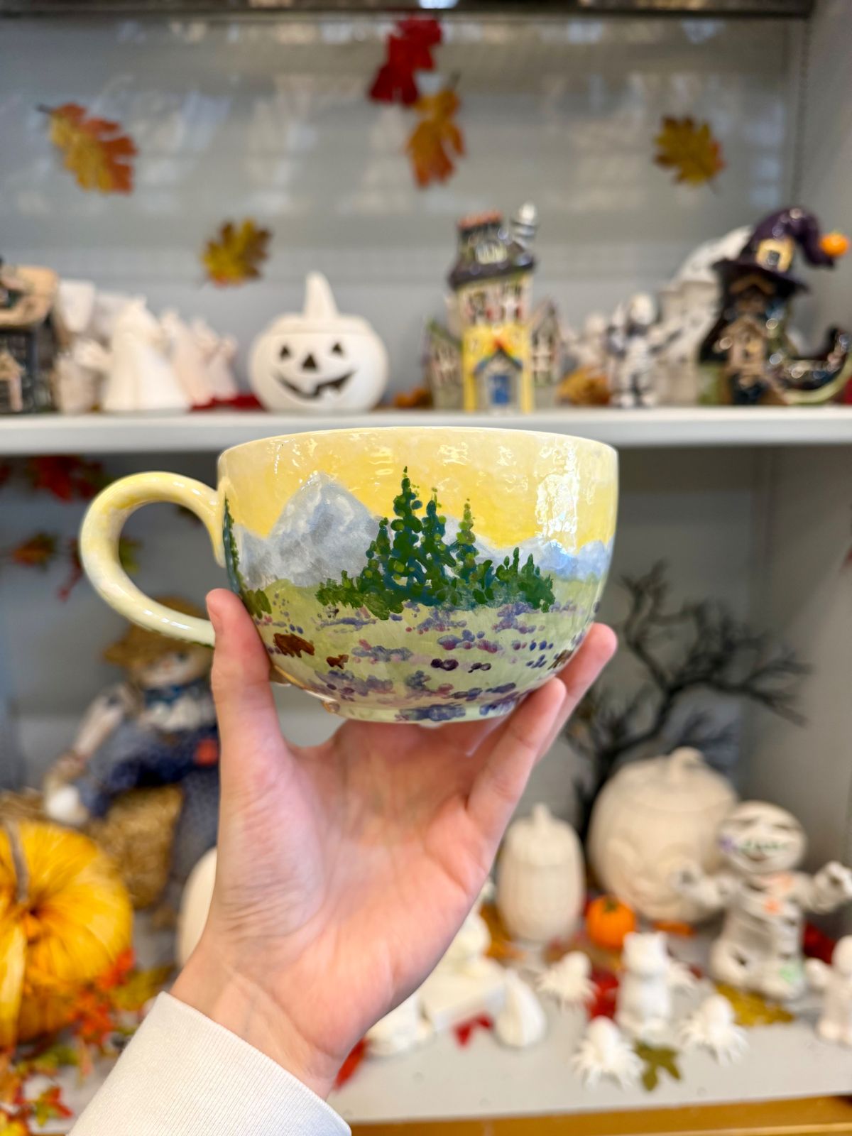 Hand-painted mug with snowy mountains and pine trees
