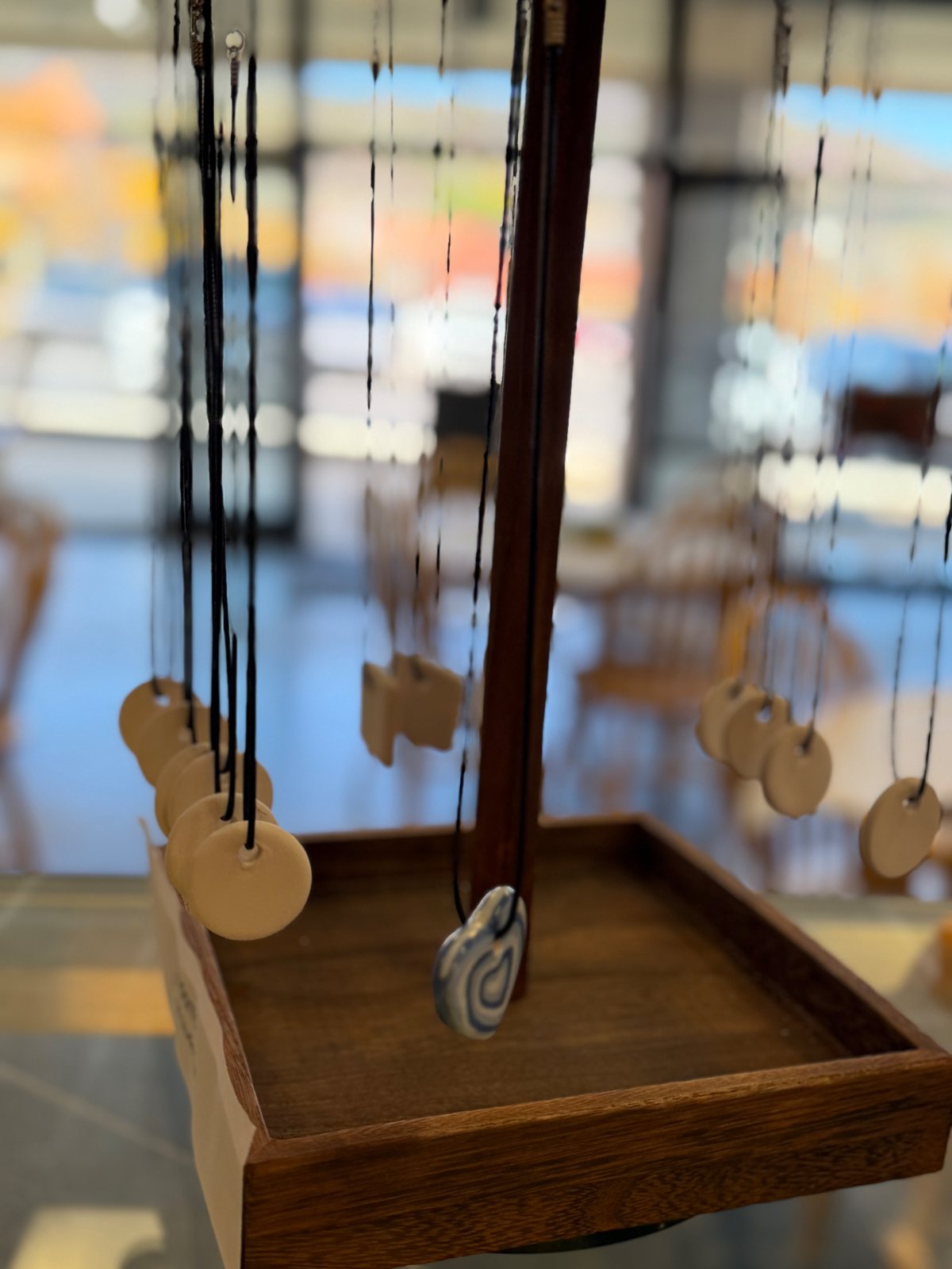 Unpainted ceramic pendant blanks on a display at Paint Fusion Park City