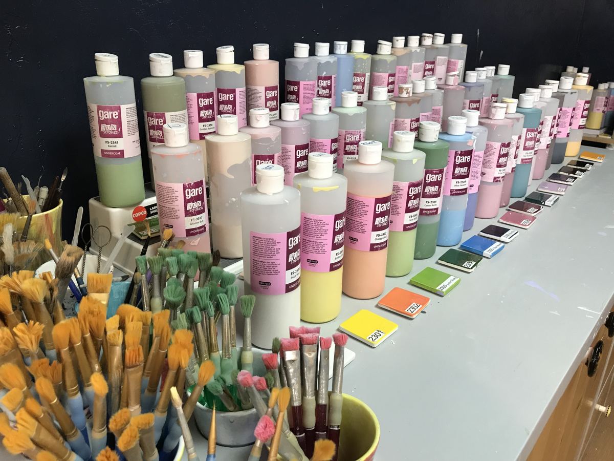 Wall of ceramic paint bottles and brushes at Paint Fusion Park City