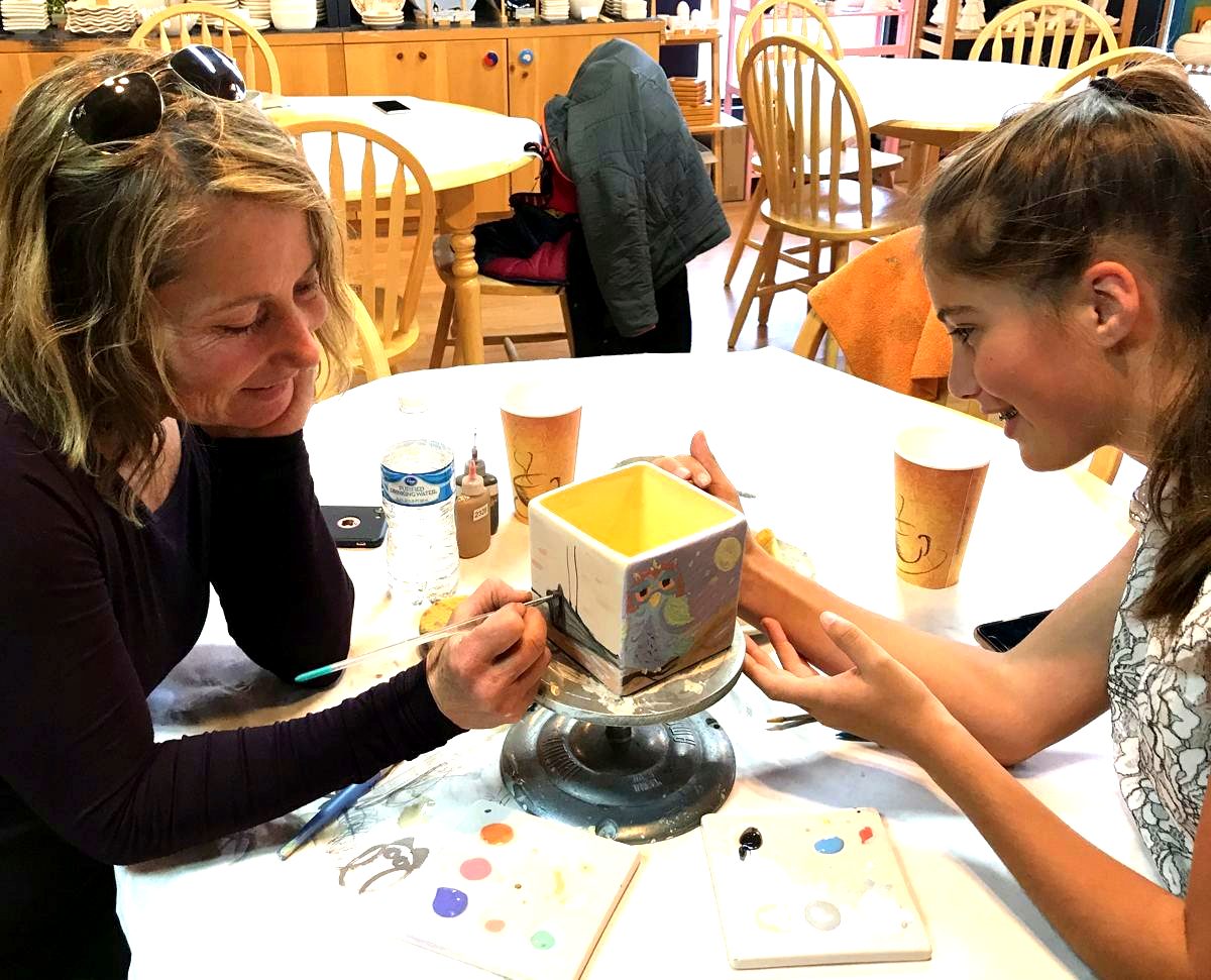 Two customers painting a ceramic keepsake box together in Park City